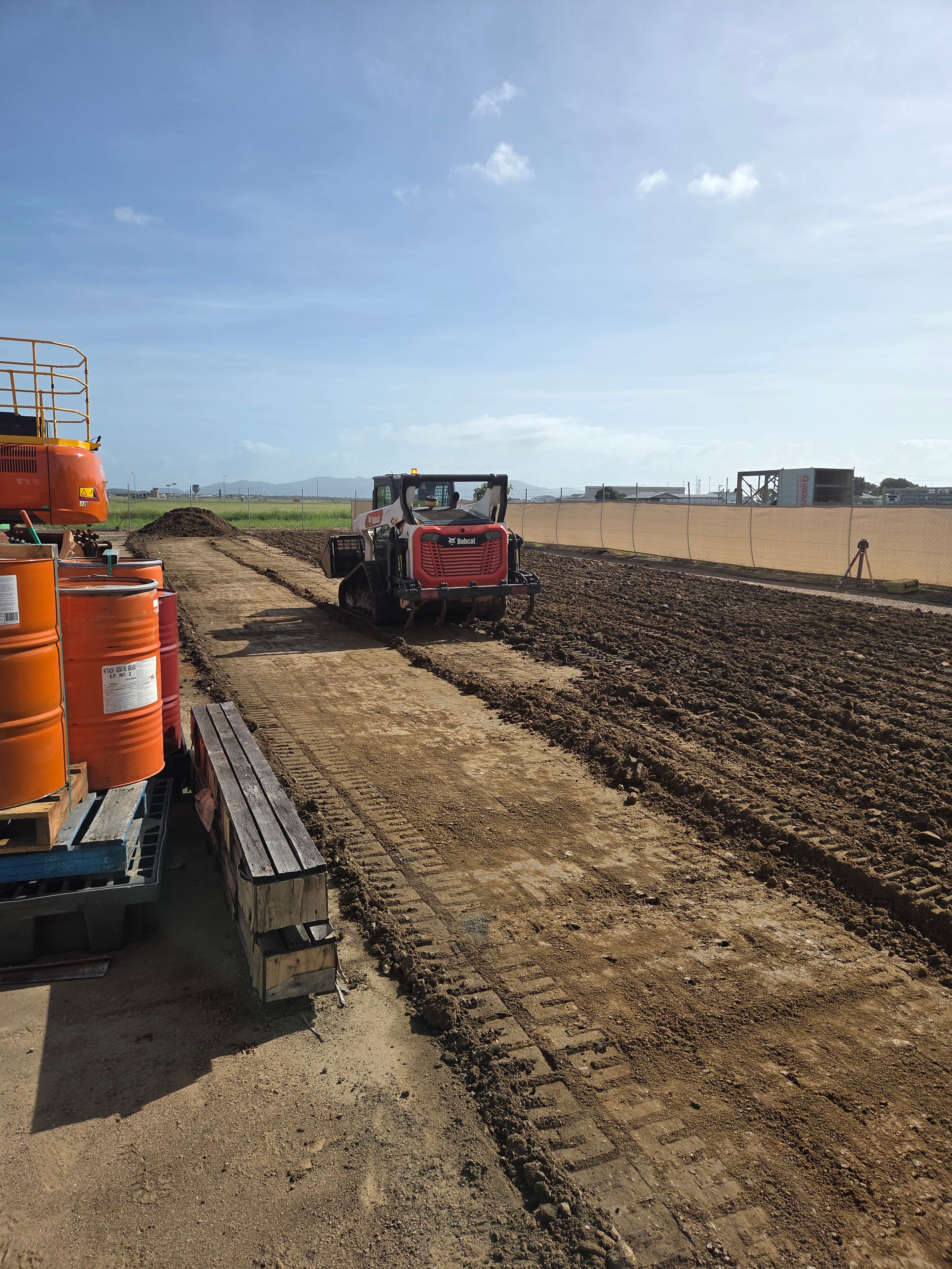Service yard re-levelling — Bobcat skid steer working across freshly graded ground