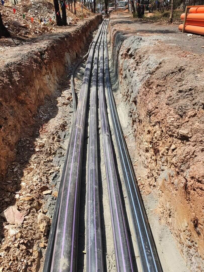 Large black cables laid in trench for underground installation